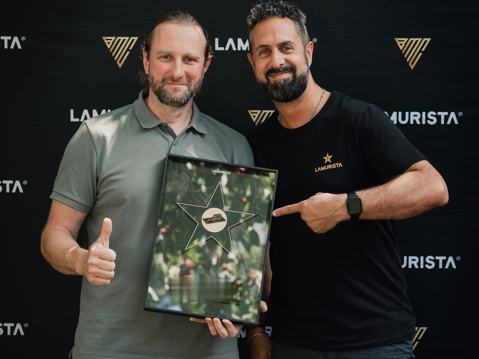 Teilnehmer präsentiert die gerahmte Lamurista Auszeichnung