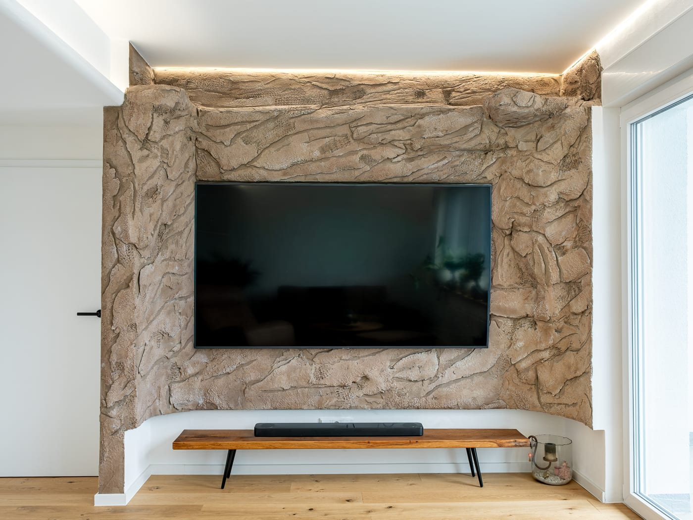 Wohnraum mit gestalteter Wand hinter dem Fernseher